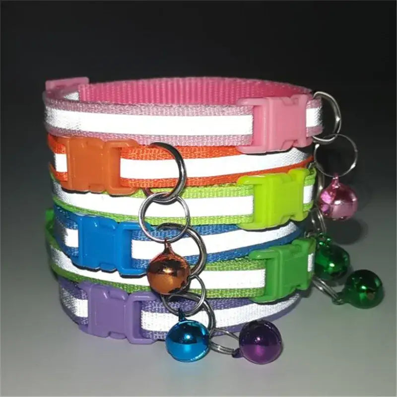 Colorful pet collars with reflective stripes and small bells attached.