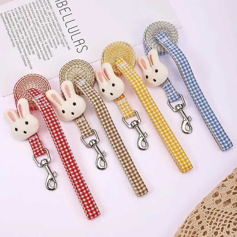 Colorful plaid pet leashes with rabbit-shaped decorations attached.