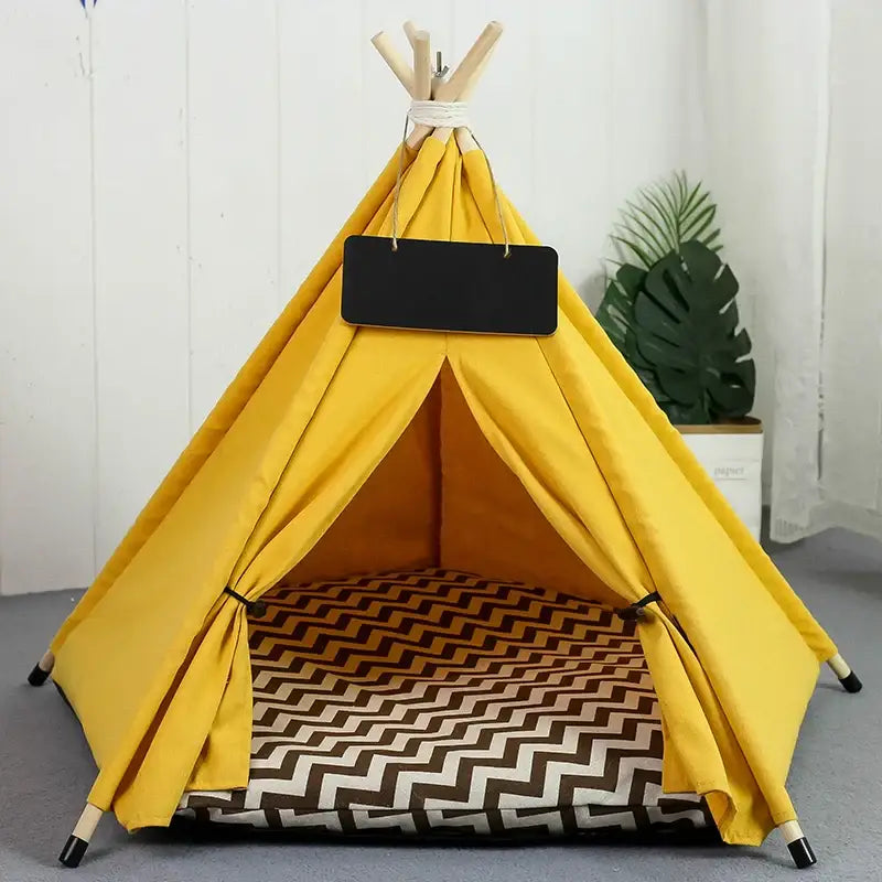 Bright yellow teepee-style tent with a black and white patterned floor cushion inside.